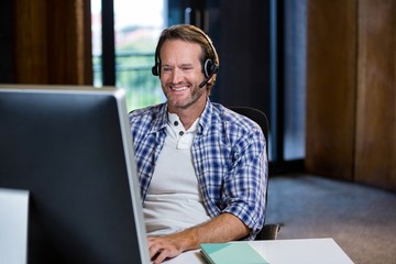 Creative businessman smiling while working on computer