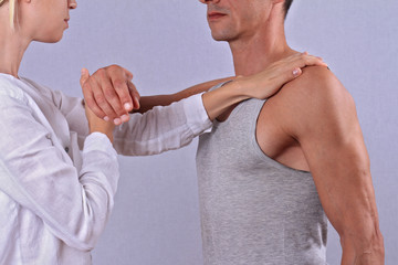 Chiropractic, osteopathy, manual therapy. Therapist doing healing treatment on man's hand /...