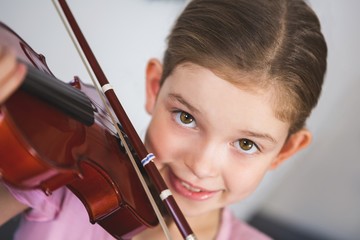 Portrait of smiling schoolgirl playing violin in classroom © WavebreakMediaMicro