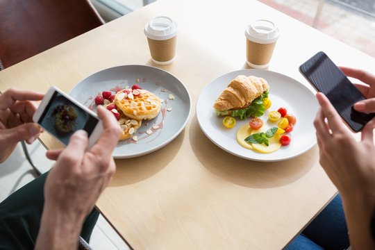 Couple taking a photo of their snacks