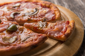 Closeup of Capricciosa Pizza on wooden table