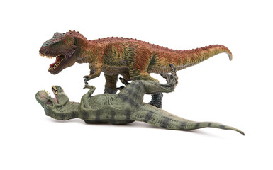 two tyrannosaurus toys on a white background, one stands and the other lays down