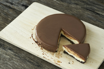Chocolate cheesecake slice on wood plate