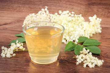 Fresh healthy juice and elderberry flowers on rustic board