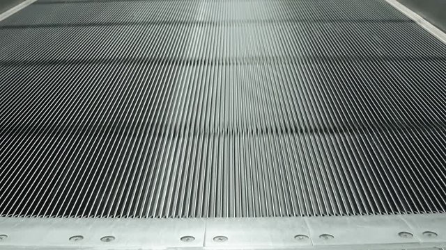 Continuous motion of a moving sidewalk as it passes under the camera's perspective at an international airport. 4k video