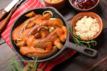 White sausages with barbecue sauce baked in a frying pan