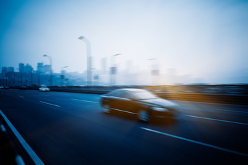 Fototapeta na wymiar motion blurred traffic with city skyline background