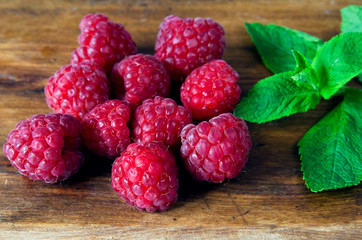 Red raspberries and a sprig of fresh green mint
