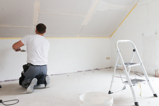 Handwerker spachtelt Gipskartonplatte - Trockenbau