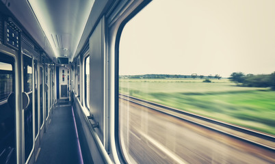 Retro toned train window with motion blurred view.