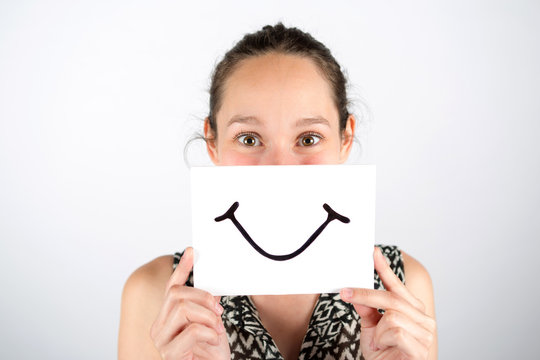 Happy woman smile hidden behind a board isolated on a white back