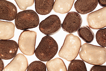 Slices of black rye bread and white bread on a white background. Food background. Pattern.