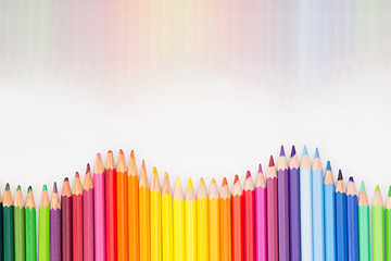 Colored pencils in rainbow order on white background. Pencils background.