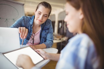 Businesswoman pointing on tablet with colleague