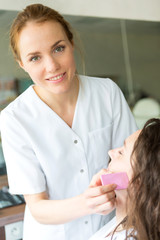 Two young beautician students working during make up classes