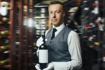 Sommelier with wine bottle in the wine cellar