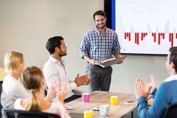Coworkers applauding a colleague after presentation