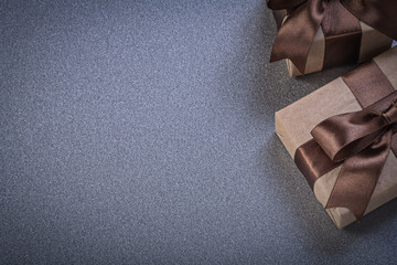 Giftboxes with brown bows on grey background celebrations concep