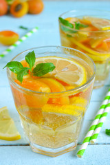 Cold, Summer lemonade with peach and apricot on a blue backgroun