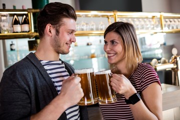 Happy young couple toasting beer mug 