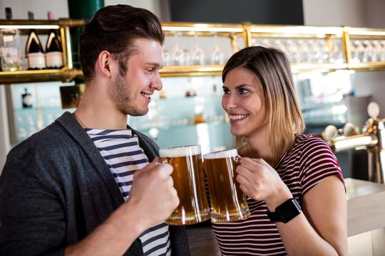 Happy young couple toasting beer mug