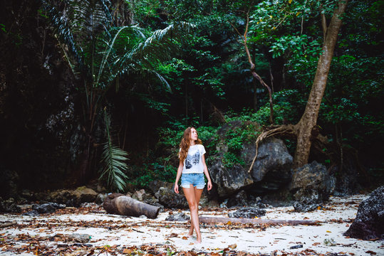 Young girl walking in tropical forest. Traveler lost in jungle