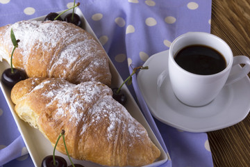 Image of alarm clock, hot coffee and croissants.