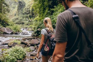 Tourist couple walking by stream © Jacob Lund