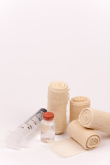Fototapeta na wymiar Bandage rolls and injection syringe bottle