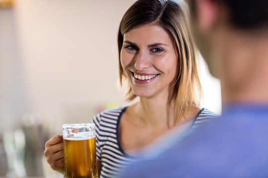 Smiling young woman holding beer mug