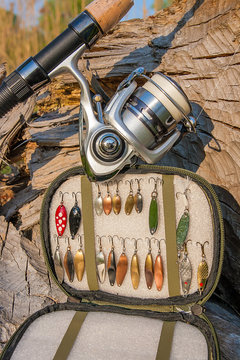 Close up view of fishing rod with reel and various kind of baits