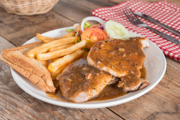 Juicy grilled pork with garlic sauce and french fries, bread.