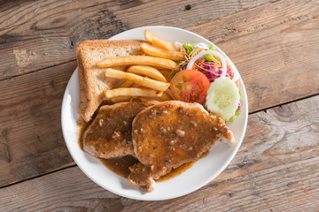 Juicy grilled pork with garlic sauce and salad, french fries. To