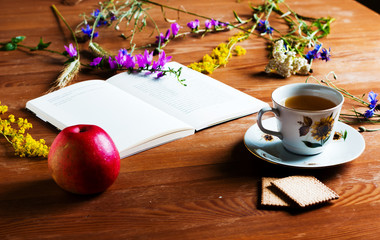 Still life in a rustic style with vintage book, wild flowers, a