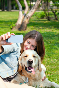 Girl and her dog selfie summer on a background of green grass