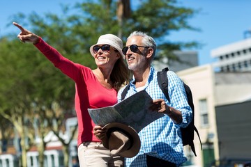 Woman pointing while standing by man in city