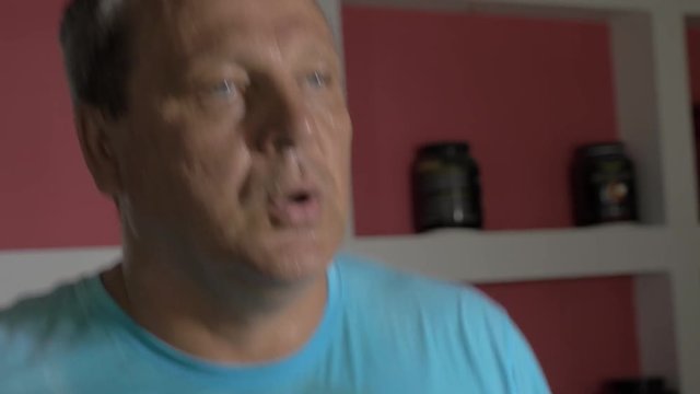 Close-up shot of a sweaty senior man working out hard on treadmill. Going in for sport to keep fit and healthy