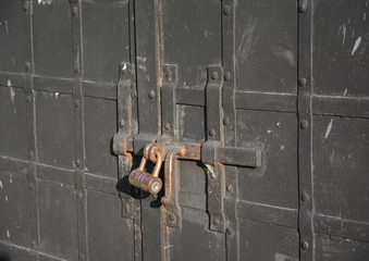 The old big padlock. Closed metal door with old lock