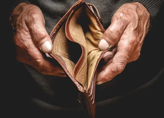Foto op Canvas Empty wallet in the hands of an elderly man. Poverty in retirement concept © perfectlab