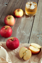 Whole and sliced apples, juice in background