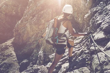 Foto auf Acrylglas Lone hiker turning to look toward rocks in sun © XtravaganT