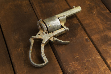 Old broken revolver on wooden board