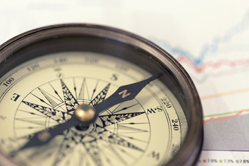 A compass on charts. A direction of success. Warm toned © Ravil Sayfullin