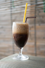 Glass of ice coffee with milk with two straws