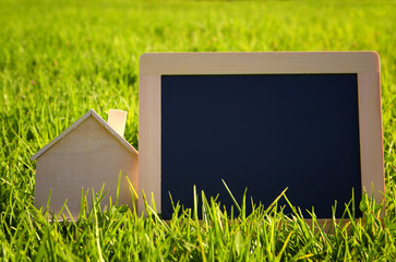 Empty chalkboard next to wooden small house