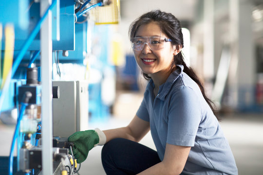 Technician operating machine in factory
