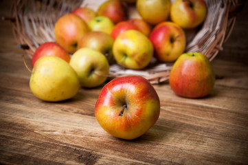 Basket with apples on wooden background