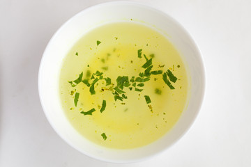 Clear soup in a white cup