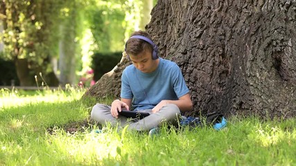 Boy with tablet at park - Powered by Adobe