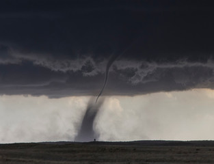  A needle shaped funnel reaches to the ground as this tornado forms over open country